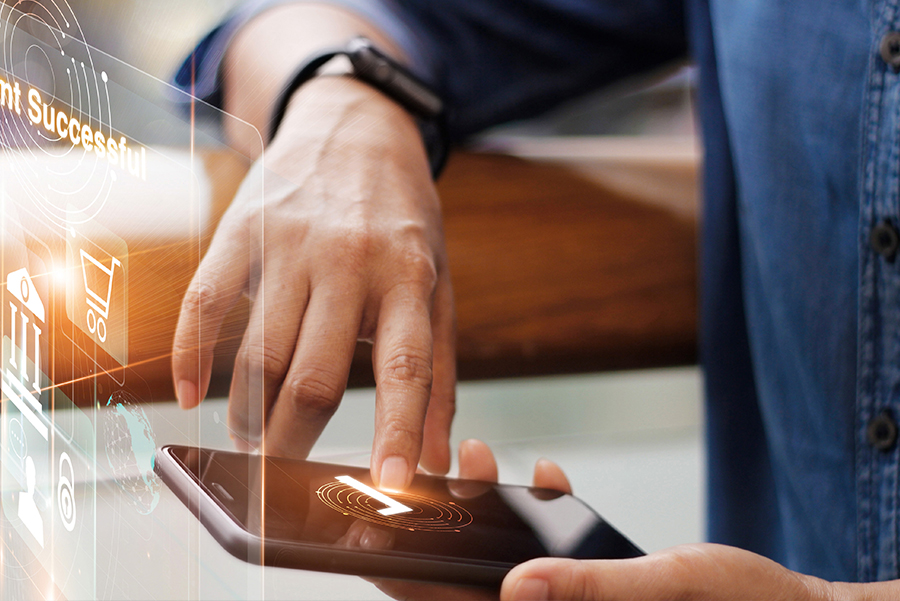 Waist up portrait of good-looking gentleman in apron holding terminal for contactless payment and smiling
